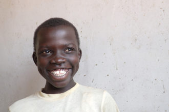 Ugandalaispoika hymyilee iloisesti