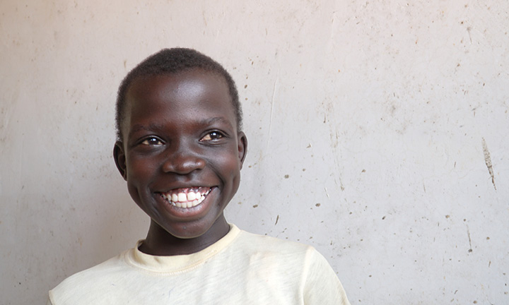 Ugandalaispoika hymyilee iloisesti