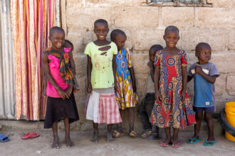 Tansanialaisia lapsia seinän vierustalla.