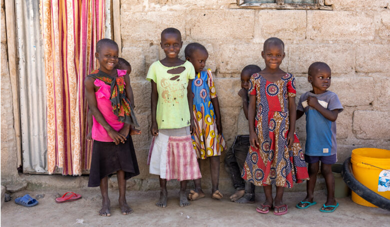 Tansanialaisia lapsia seinän vierustalla.