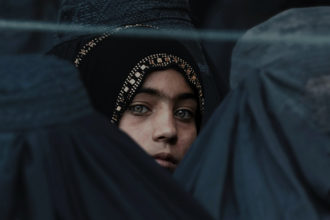 Afganistanilainen tyttö burkhaan pukeutuneena.