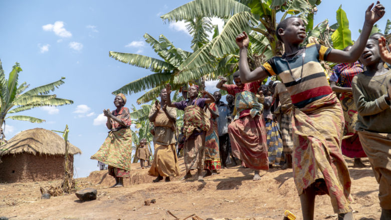 Burundilaiset naiset tanssivat iloisesti palmujen alla.