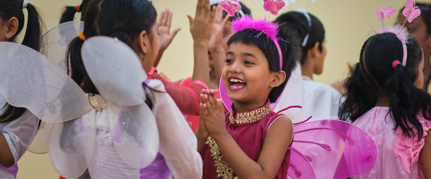Bangladeshilaiset pikkutytöt iloitsevat koulussa.
