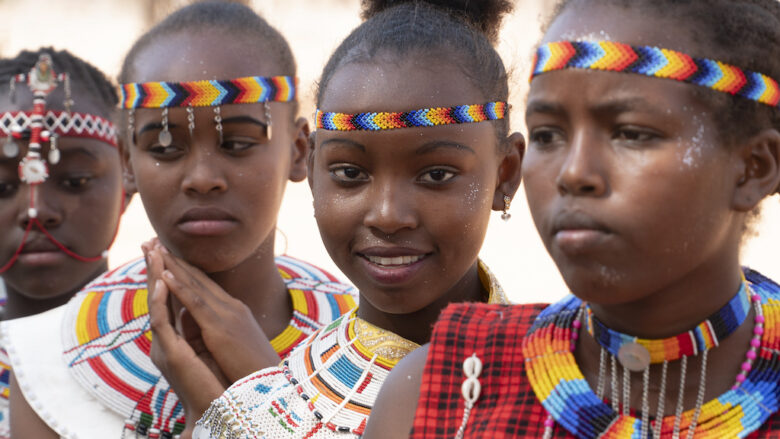 Kenialaisia tyttöjä värikkäissä vaatteissa ja hiuspannoissa.