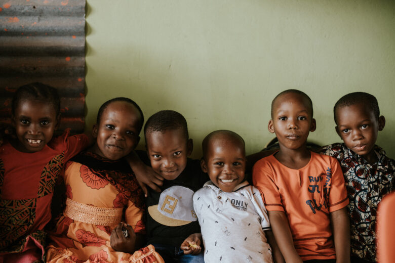 Tansanialaisia lapsia rivissä, he hymyilevät.