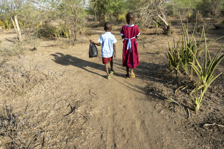 Samson ja Stella kävelevät koulua kohti kuivaa polkua pitkin.