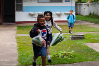 Lapset juoksevat kouluun.