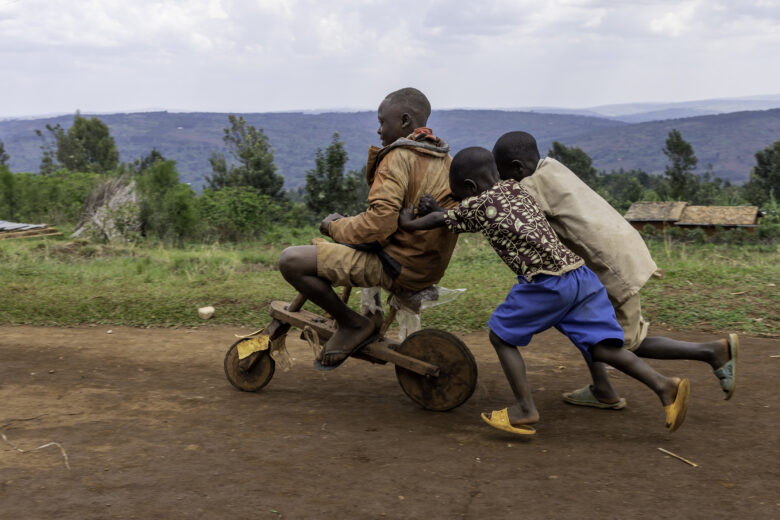 Burundilaiset pojat leikkivät puisella potkulaudalla.